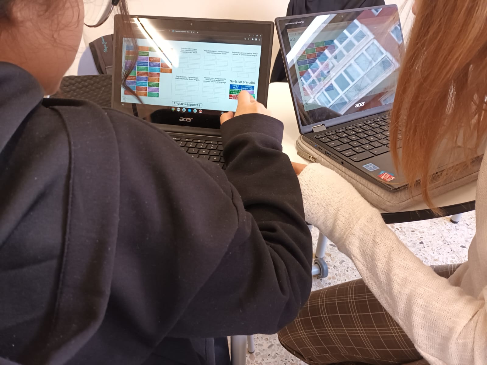 Dues alumnes resolent l'activitat conjuntament, cadascuna en el seu Chromebook.